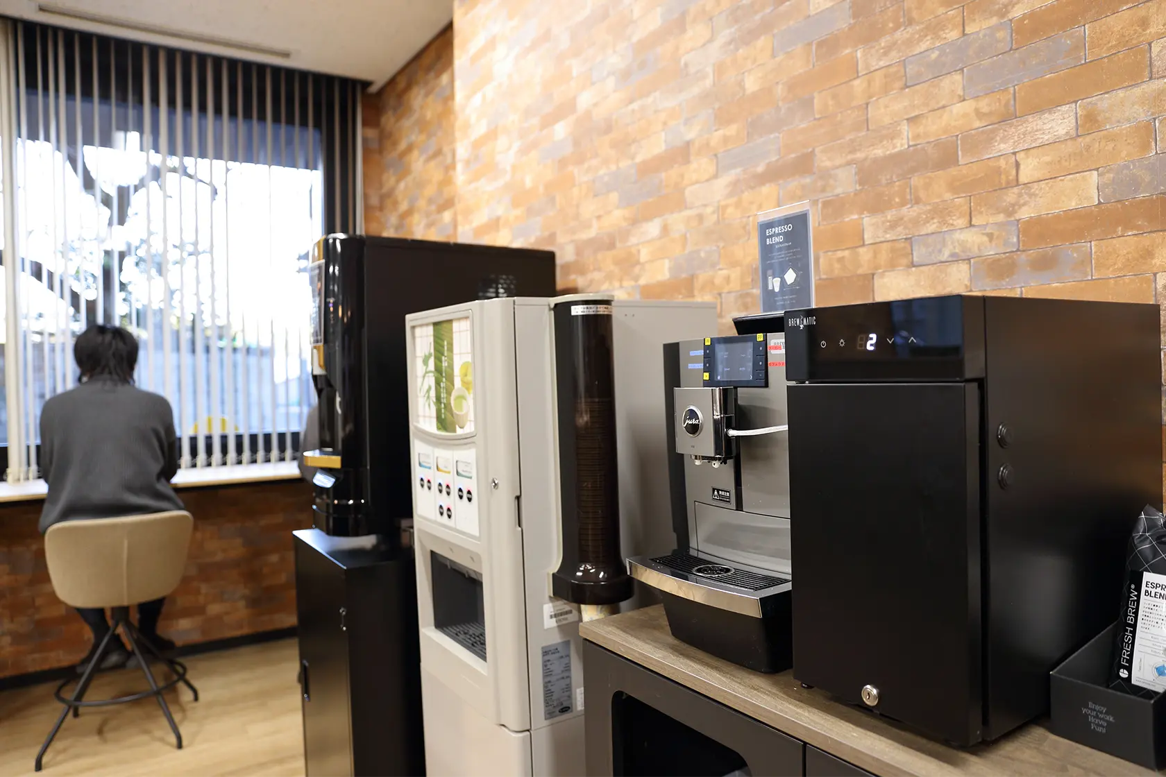 社内風景。オフィス内のリフレッシュスペースに設置されたコーヒーマシンとドリンクサーバー。